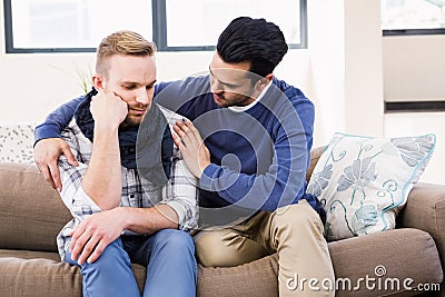 Gay couple comforting each other on the couch Stock Photo