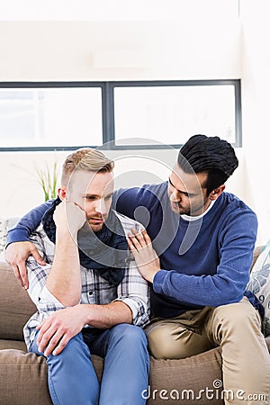 Gay couple comforting each other on the couch Stock Photo