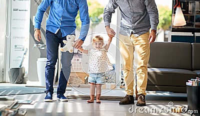 Gay couple with child in store for household Stock Photo