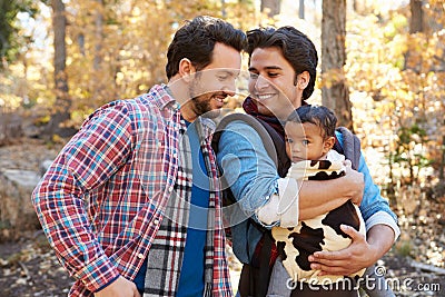 Gay Male Couple With Baby Walking Through Fall Woodland Stock Photo