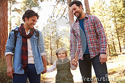 Gay Male Couple With Daughter Walking Through Fall Woodland Stock Photo