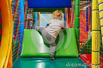 Gdansk, Poland: 30th December 2018 - Child trying to climb over an abstacle on a softplay Editorial Stock Photo