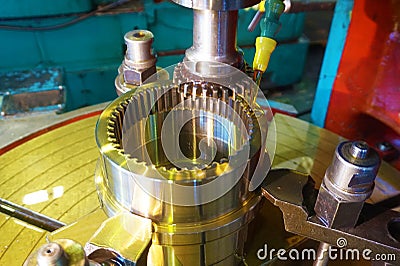 Gear cutter. Cutting the tooth on the tooth with a slotting machine with oil cooling. Metal-working industry. Stock Photo
