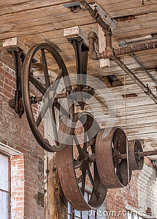 Gears and pulleys on a ceiling in old warehouse Stock Photo