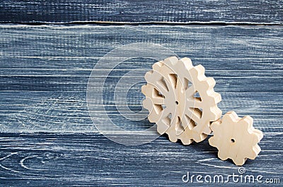 Gears of wood stand on a dark wooden background. Concept of technology and industry, engineering. Mechanical parts, technological Stock Photo