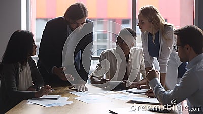 Geconcentreerd gemengd ras commercieel team die marketing onderzoeksresultaten bespreken. stock videobeelden Geconcentreerd gemengd ras commercieel team die marketing onderzoeksresultaten bespreken. stock videobeelden