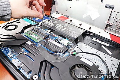 A geek cleans a laptop cooler. Contaminated computer cooling system. Stock Photo