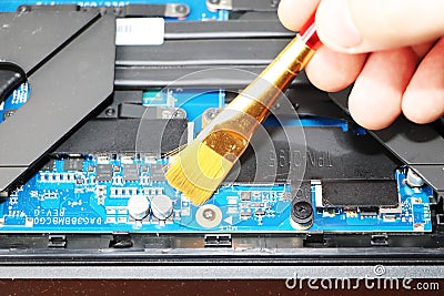 A geek cleans a laptop cooler. Contaminated computer cooling system. Stock Photo