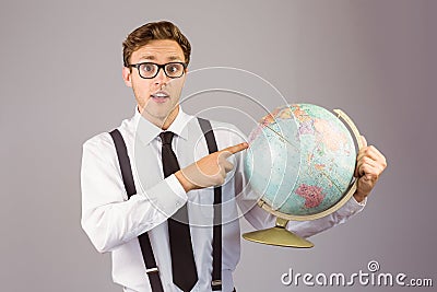 Geeky businessman pointing to globe Stock Photo