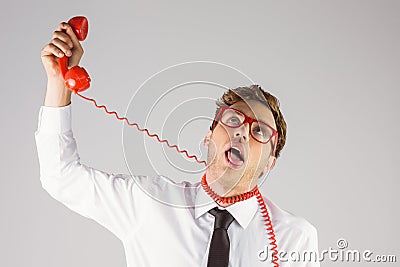 Geeky businessman strangling himself with telephone Stock Photo