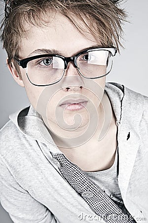 Geeky Looking Teenager against Grey Background Stock Photo