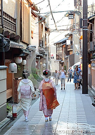 A geisha and a maiko walk down the streets of Miyagawacho neighborhood in Kyoto Editorial Stock Photo