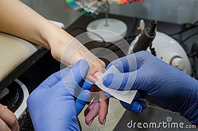 Gel polish manicure process. Salon procedure. Master leaks nails with a napkin. Stock Photo