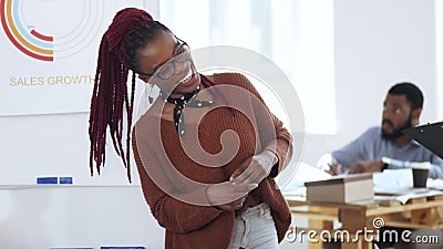 Gelukkige jonge toevallige Afrikaanse vrouwenwerkgever in oogglazen die bespreking leiden, die tot collega's op modern licht kant stock footage Gelukkige jonge toevallige Afrikaanse vrouwenwerkgever in oogglazen die bespreking leiden, die tot collega's op modern licht kant stock footage