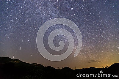 Geminid Meteor Shower and the Milky Way Over a mountain. Geminid Meteor in the night sky Stock Photo