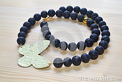 Gemstone black lava necklace with gold butterfly Stock Photo