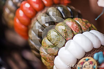 Gemstone bracelets and necklaces in a row. Jewelry made of red jasper, unakite stones, obsidian stones and white onyx stone. Stock Photo