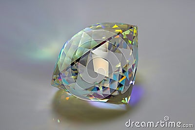 Gemstone of clear Optical K9 glass with Round Brilliant Portuguese cut, on a white Plexiglas background, photographed from the sid Stock Photo