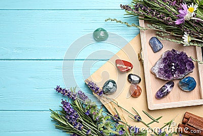 Gemstones and healing herbs on blue wooden table, flat lay. Space for text Stock Photo