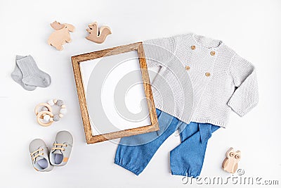 Gender neutral baby garment and accessories and empty frame mockup. Organic cotton clothes Stock Photo