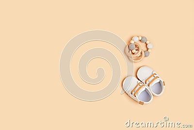 Gender neutral baby shoes and accessories over beige background. Stock Photo