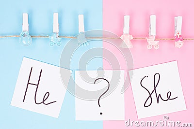 Gender reveal gathering party concept. Close up photo of small clothespins with little footprint beanbag bib hanging on a rope Stock Photo