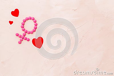 Gender Venus symbol made of contraceptive pills, near heart sign - woman health concept - on beige background top-down Stock Photo