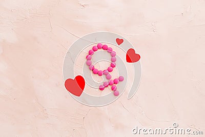 Gender Venus symbol made of contraceptive pills, near heart sign - woman health concept - on beige background top-down Stock Photo