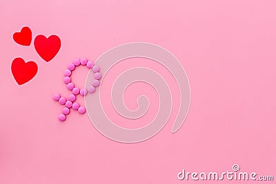 Gender Venus symbol made of contraceptive pills, near heart sign - woman health concept - on pink background top-down Stock Photo