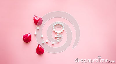Gender Venus symbol made of pills, and peony flower petals on a pink background. Stock Photo