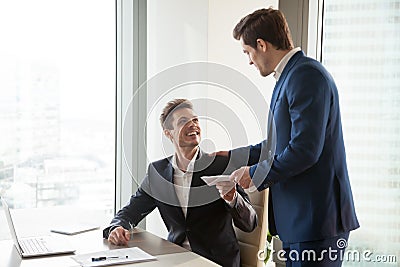 Boss giving money premium to happy employee Stock Photo