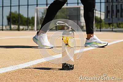 Transparent freshness glass bottle of water in sunny day on sport ground. Stock Photo