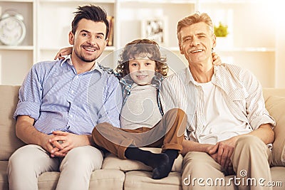 Generation portrait. Grandfather, father and son sitting on sofa Stock Photo