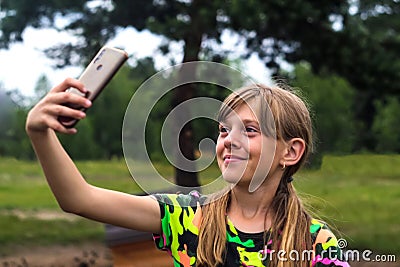 Generation z. A ten year old girl poses and takes a selfie by hand Happy Young Girl Taking Selfie By Smartphone Blogging Stock Photo