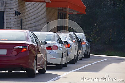 Generic drive thru pickup window with cars waiting in line to get their products or food Stock Photo