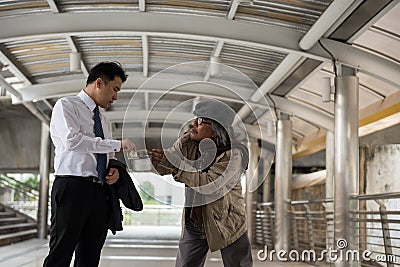 Kind businessman give money to beggar Stock Photo