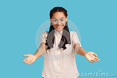 Generous woman standing with wide open hands as if sharing for free, giving charity and smiling. Stock Photo