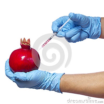 Genetic injection into pomegranate isolated on white background. Genetically modified fruit and syringe Stock Photo