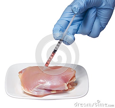 Genetic injection into raw chicken meat on square plate isolated on white background. Genetically modified food and syringe Stock Photo