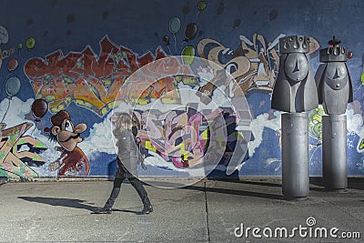 GENEVA, SWITZERLAND - FEBRUARY, 2019 - Woman walk near the mural of the Grottes school playground adjacent to Jean-Robert-Chouet t Editorial Stock Photo