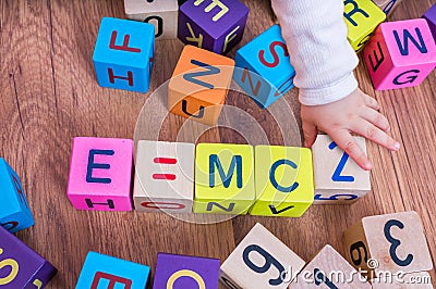 Genius baby with high IQ is playing with cubes and writing formulas Stock Photo