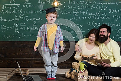 Genius child in graduation cap. Little genius answer hometask in classroom. Family proud of genius son. Genius without Stock Photo