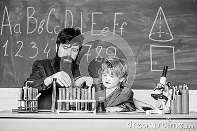 Genius kid. Joys and challenges raising gifted child. Teacher bearded scientist man child test tubes. Chemical Stock Photo