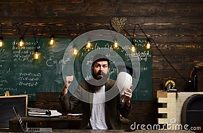 Genius man with beard hold bulb on chalkboard. Genius businessman with lightbulb got idea in classroom, enlightenment Stock Photo