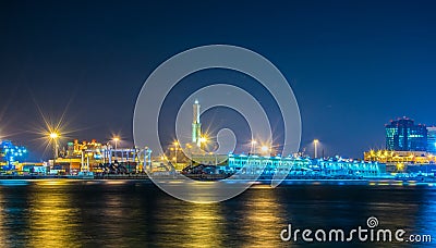 GENOA, ITALY, MARCH 13, 2016: night view of the historical lighthouse in the port of genoa together with sechc cargo Editorial Stock Photo