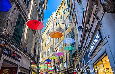 Genoa, Italy, September 11, 2018: colorful multicolored open umbrellas parasols hang among old buildings Editorial Stock Photo
