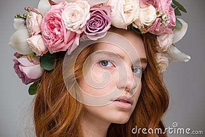 Gentle beautiful girl with red hair in wreath of roses Stock Photo