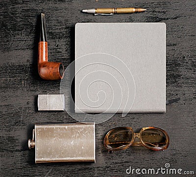 Gentlemanly set: flask for whiskey, lighter, sun glasses, notebook, pen and smoking pipe. Stock Photo