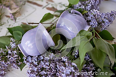Gently purple bowl in the shape of a Bud, covered with icing. The skill of the ceramist.With branches of fluffy lilac Stock Photo