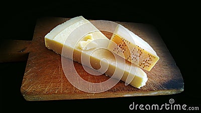 Genuine slice of parmigiano reggiano on the chopping board Stock Photo